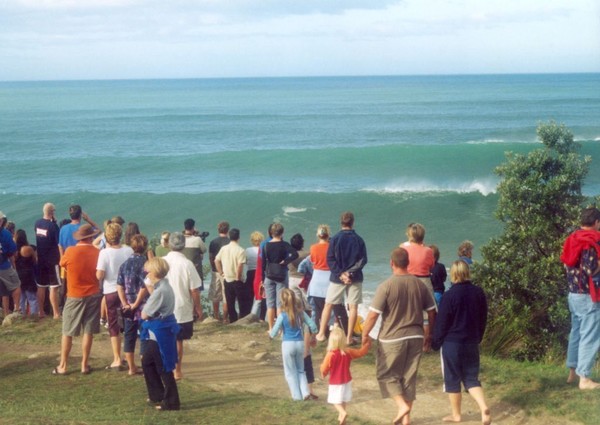 On lookers flock to the end of Moturiki Island, Mount Maunganui to watch surfers tackle 20-30 foot high waves breaking in perfect conditions during Cyclone Ivy, February 2004.